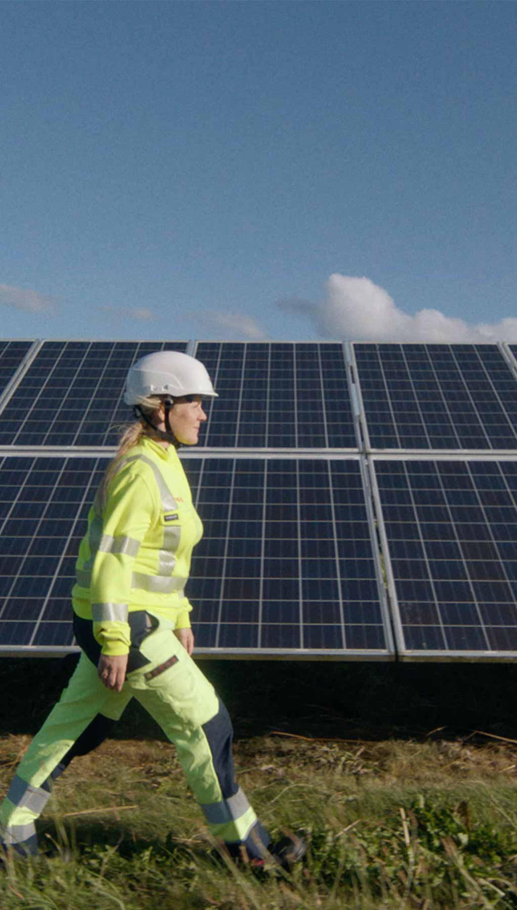 Woman walking past a solar panel farm
