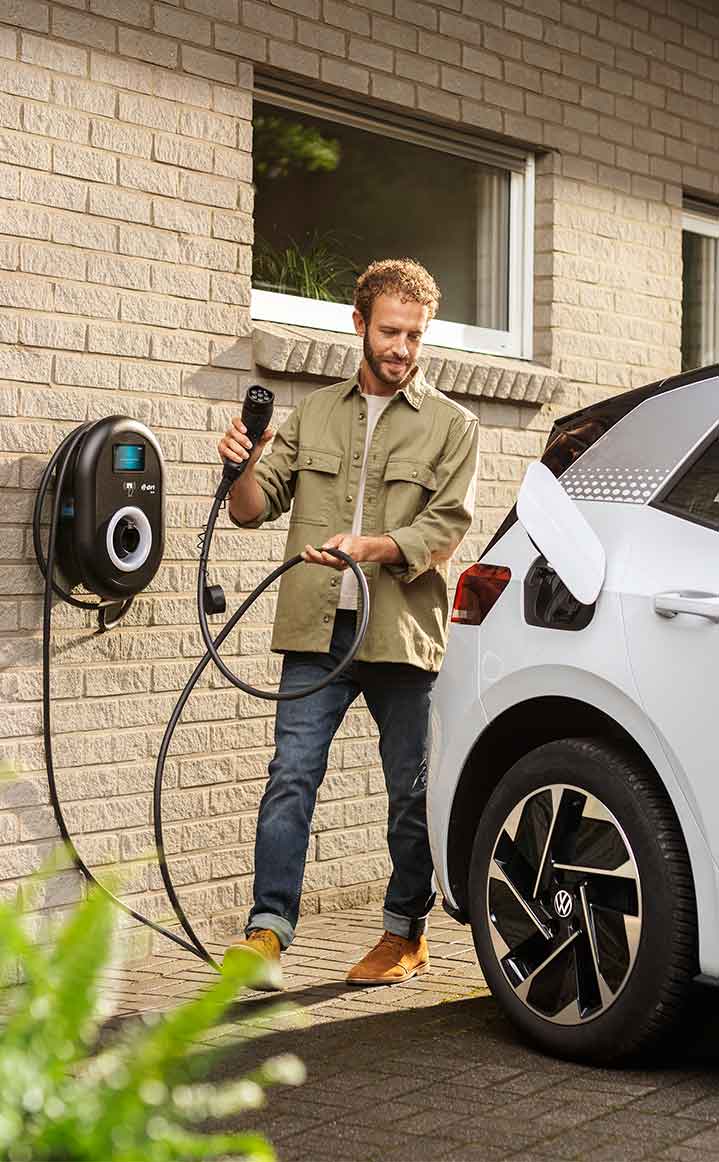 man charging electric car with home charger