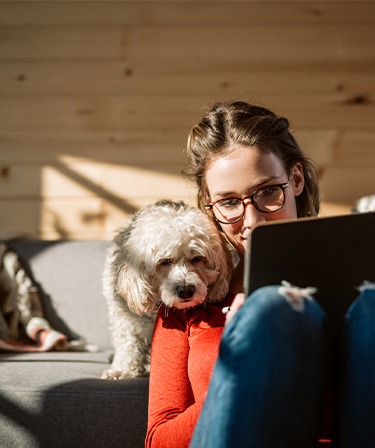 Image of a woman with her dog looking at a tablet