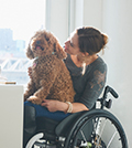 Image of a woman in a wheelchair with a dog on her lap