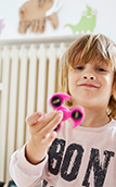 Image of a boy in front of a radiator playing with a fidget spinner