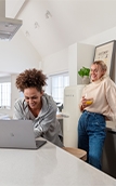 Image of two women in a kitchen looking at a laptop