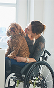 Image of a woman in a wheelchair with a dog on her lap