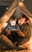 Image of a father and son in a Teepee tent inside their house 