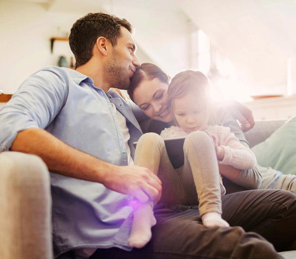 Family on sofa controlling their new boiler with their smart meter