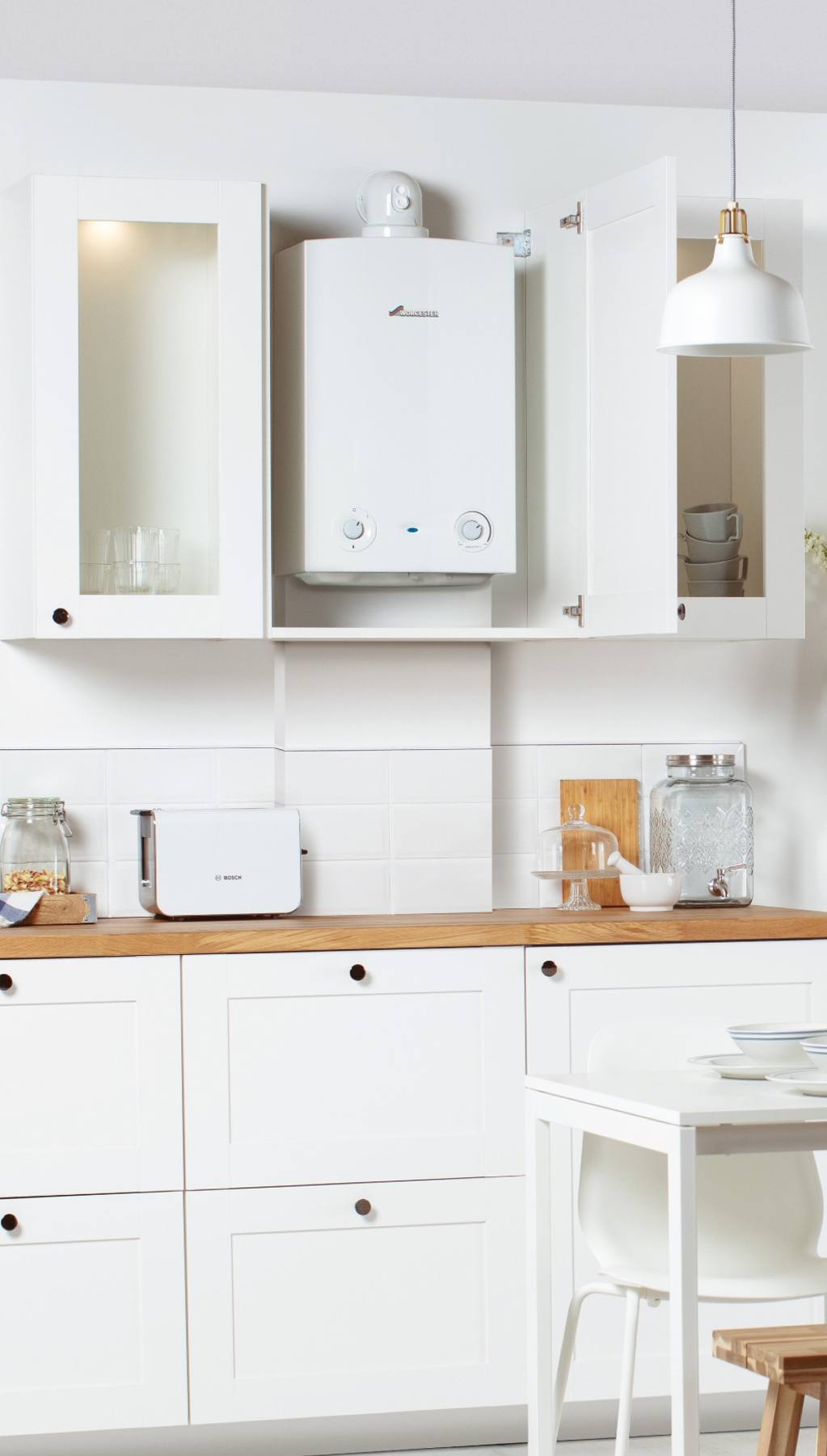 Regular boiler installed in a cupboard, in a white kitchen