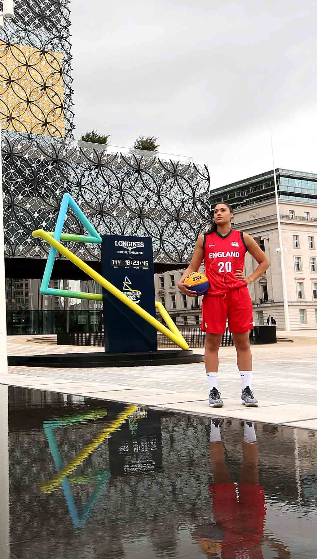 Female Basketball Athlete in front of Games logo