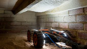 Image of a Q-Bot robot spraying underfloor insulation