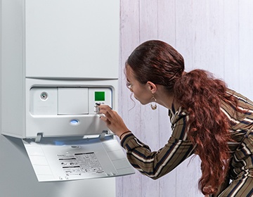 Image of a woman looking at her boiler controls