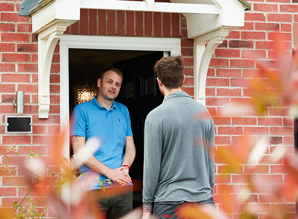 Image of an E.ON engineer being greeted at a customer door