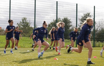 Female footballers training on pitch