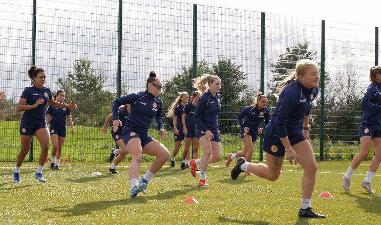 Female footballers training on pitch 